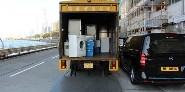 white front-load washer in yellow delivery truck