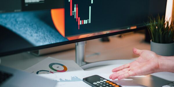 a person pointing at a calculator on a desk